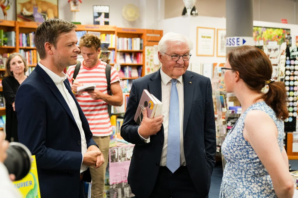 Bundespräsident Frank-Walter Steinmeier spricht mit einer Mitarbeitern in der Fontane-Buchhandlung Neuruppin